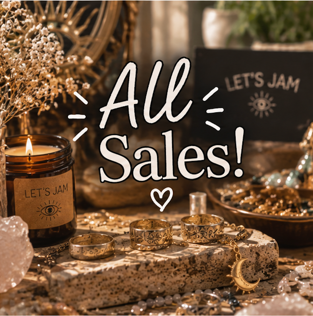All Sales - Let's Jam sale, silver rings, a gold moon charm and crystals beside a Let's Jam candle - Camden Market, London