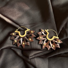 Load image into Gallery viewer, Pair of handcrafted brass hoop earrings with sculpted dark wood lotus flower petals riveted on, displayed on dark satin fabric - Let's Jam jewellery collection
