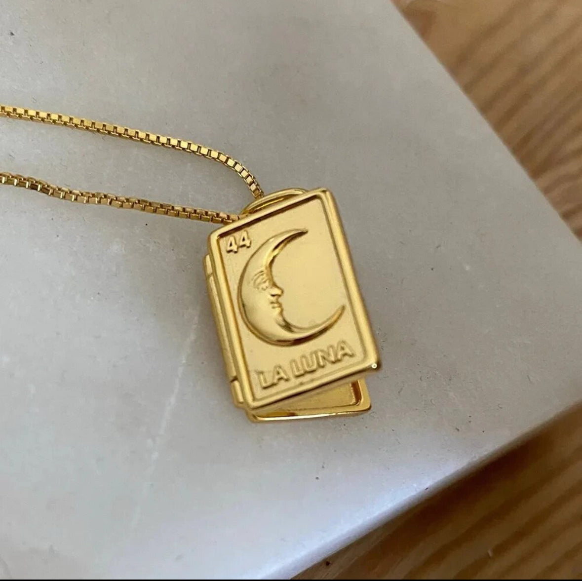 Gold moon locket pendant closed, engraved crescent design on the front - Let's Jam jewellery, Camden Market