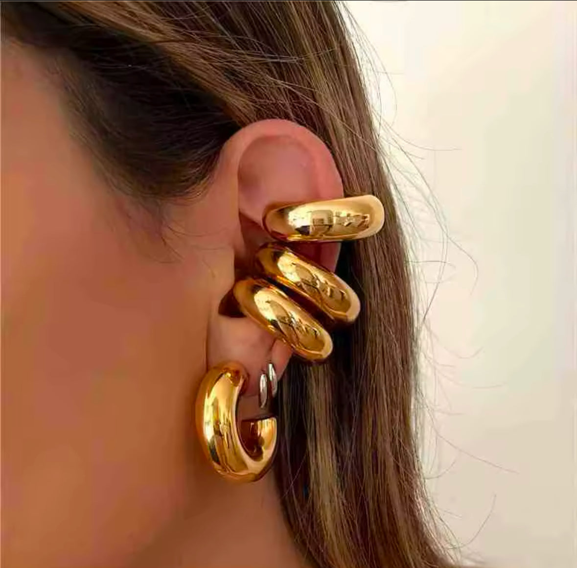 Close-up of a gold cuff hugging the upper ear beside a hoop earring - Let's Jam, Camden Market London