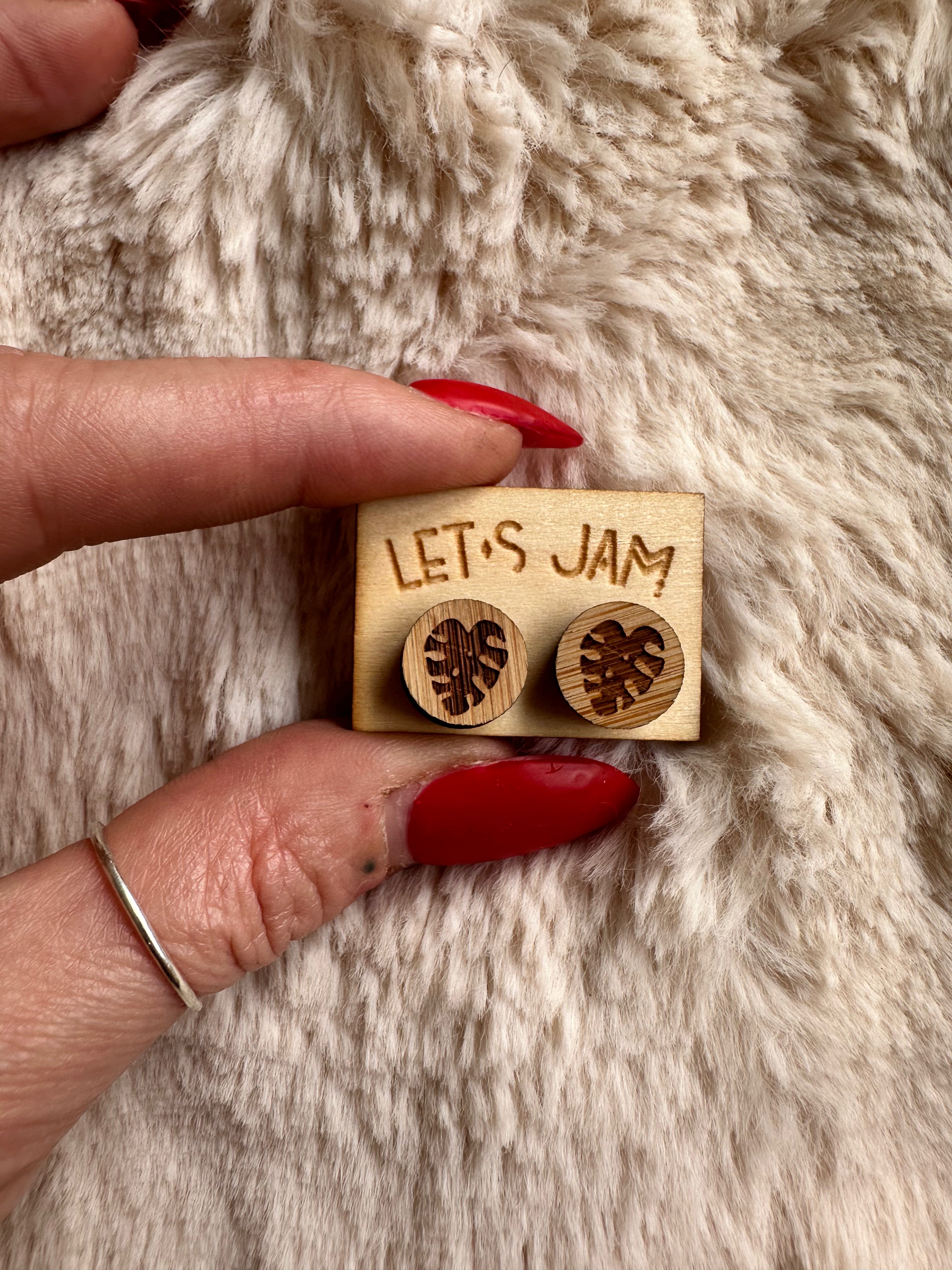 Pair of engraved wooden leaf studs shown on a display card - Let's Jam, Camden Market London