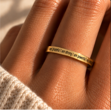 Load image into Gallery viewer, A close-up of a hand wearing a thin gold band ring engraved with the positive affirmation, 'I am grateful I am strong I am powerful I am happy'.