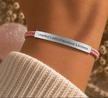 Load image into Gallery viewer, Pink braided bracelet with a silver engraved plate, worn with a knit jumper - Let's Jam, Camden Town London