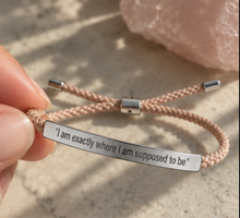 Load image into Gallery viewer, Hand holding a braided cord bracelet with a silver engraved bar - Let's Jam jewellery, Camden Market, London