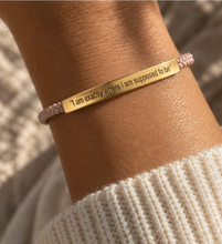 Load image into Gallery viewer, Pale pink cord bracelet with a gold engraved bar, worn with a knit jumper - Let's Jam, Camden Market