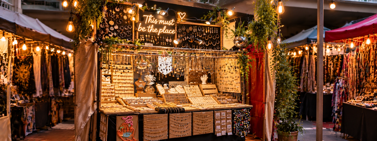 Warm, lantern-lit jewellery market stall full of necklaces and rings - Let's Jam, Camden Town