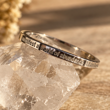 Load image into Gallery viewer, Silver 'I manifest a world of abundance & kindness' ring on a quartz crystal - Let's Jam, Camden Market London