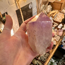 Load image into Gallery viewer, Amethyst crystal point held in the hand to show its size - Let's Jam, Camden Market, London
