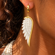 Load image into Gallery viewer, White carved angel wing earring edged in gold, worn close up - Let's Jam, Camden Market