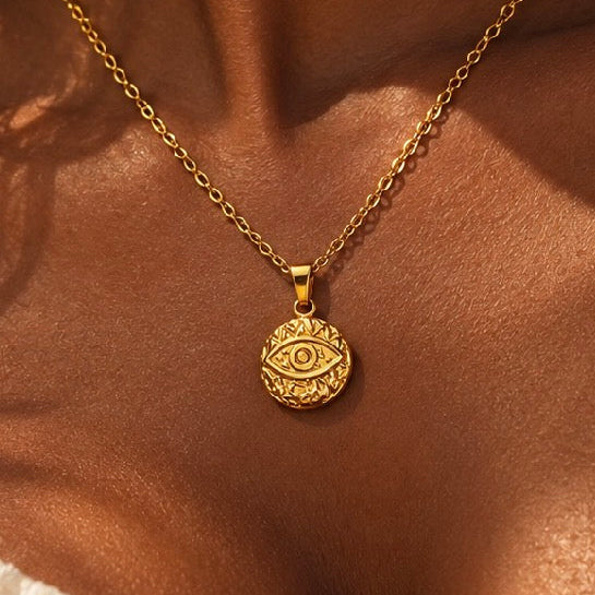 Close-up of a gold third eye medallion necklace worn - Let's Jam, Camden Market, London