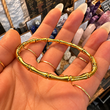Load image into Gallery viewer, Gold bamboo clip bangle laid in the palm - Let's Jam, Camden Town London