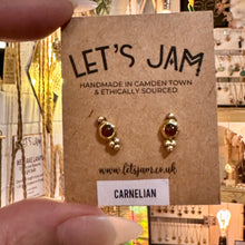 Load image into Gallery viewer, Dainty brass stud earrings with red carnelian stones on their gift card - Let's Jam, Camden Town