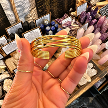 Load image into Gallery viewer, Gold cuff bangle with fine woven bands held in the hand - Let's Jam jewellery, Camden Market, London