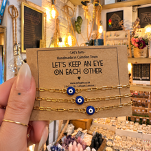 Load image into Gallery viewer, Gold evil eye matching bracelets on a Let's Keep An Eye On Each Other card - Let's Jam, Camden Market, London