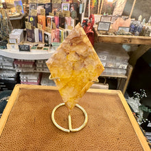 Load image into Gallery viewer, Fire quartz point held up to the light to show its golden flashes - Let's Jam, Camden Market, London