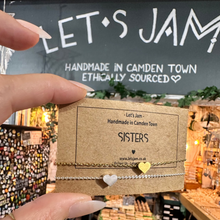 Load image into Gallery viewer, Two matching silver chain bracelets with heart charms on a kraft display card - Let's Jam jewellery, Camden Market