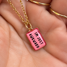 Load image into Gallery viewer, Pink ceramic pendant reading I'm just awkward held in the hand - Let's Jam, Camden Market, London
