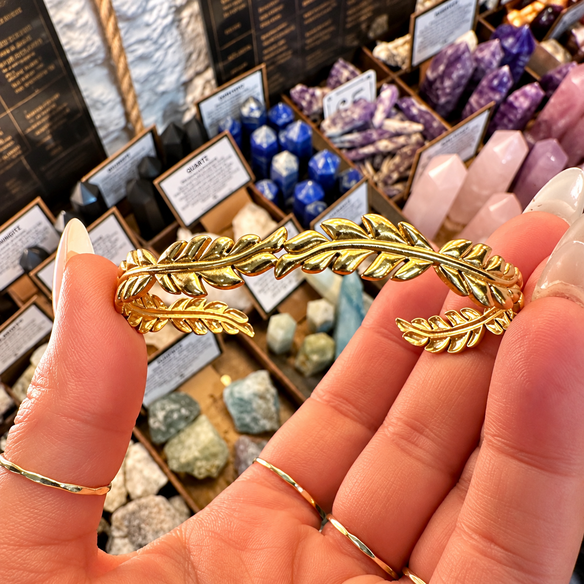 Gold cuff bangle with leaf ends held in the hand - Let's Jam, Camden Market