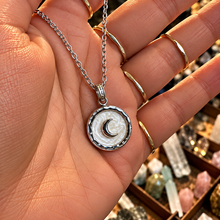 Load image into Gallery viewer, Silver round pendant with a crescent moon held in the hand - Let's Jam, Camden Market, London