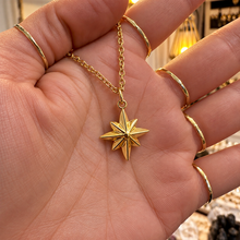 Load image into Gallery viewer, Gold eight-point northern star pendant held in the hand - Let's Jam, Camden Market, London