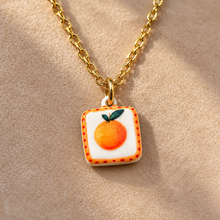 Load image into Gallery viewer, Close-up of the square ceramic pendant hand painted with an orange - Let's Jam, Camden Town London