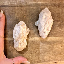 Load image into Gallery viewer, Both raw milky quartz points next to a hand to show their size - Let's Jam, Camden Market