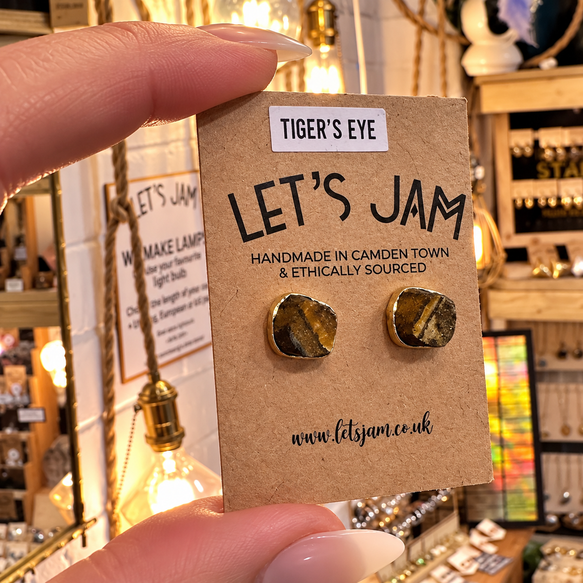 Raw tiger's eye stud earrings on a branded card held in the hand - Let's Jam, Camden Town