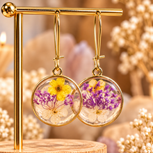 Load image into Gallery viewer, Round resin earrings with real yellow and purple pressed flowers on a gold stand - Let's Jam jewellery, Camden Market, London