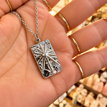 Load image into Gallery viewer, Silver rectangle pendant with a starburst held in the hand - Let's Jam jewellery, Camden Market, London