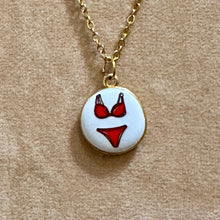 Load image into Gallery viewer, Close-up of a round white ceramic pendant hand painted with a red bikini - Let's Jam, Camden Town