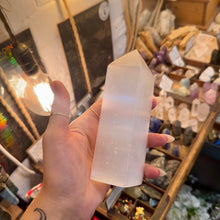 Load image into Gallery viewer, Selenite obelisk held in the hand to show its size - Let's Jam, Camden Market London