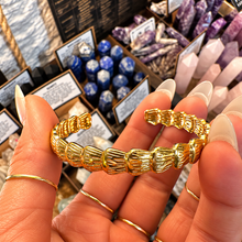 Load image into Gallery viewer, Gold cuff bangle of scalloped shells held in the hand - Let's Jam jewellery, Camden Market