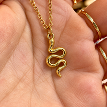 Load image into Gallery viewer, Gold serpent pendant on a fine chain held in the hand - Let's Jam, Camden Market London