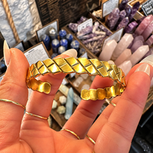 Load image into Gallery viewer, Front of the woven gold cuff bangle held up - Let's Jam jewellery, Camden Town London