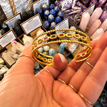 Load image into Gallery viewer, Open gold cuff with chain links and twisted bands held in the palm - Let's Jam, Camden Market London