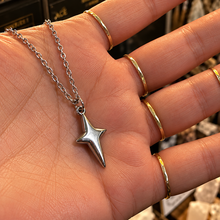 Load image into Gallery viewer, Silver four-point star pendant held in the hand - Let's Jam jewellery, Camden Market, London