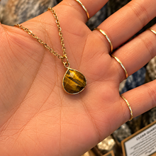 Load image into Gallery viewer, Tiger's eye pendant on a gold chain held in the hand - Let's Jam jewellery, Camden Market London