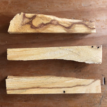 Load image into Gallery viewer, Palo santo stick lit at one end with smoke curling upwards - Let's Jam smudge shop, Camden Market, London