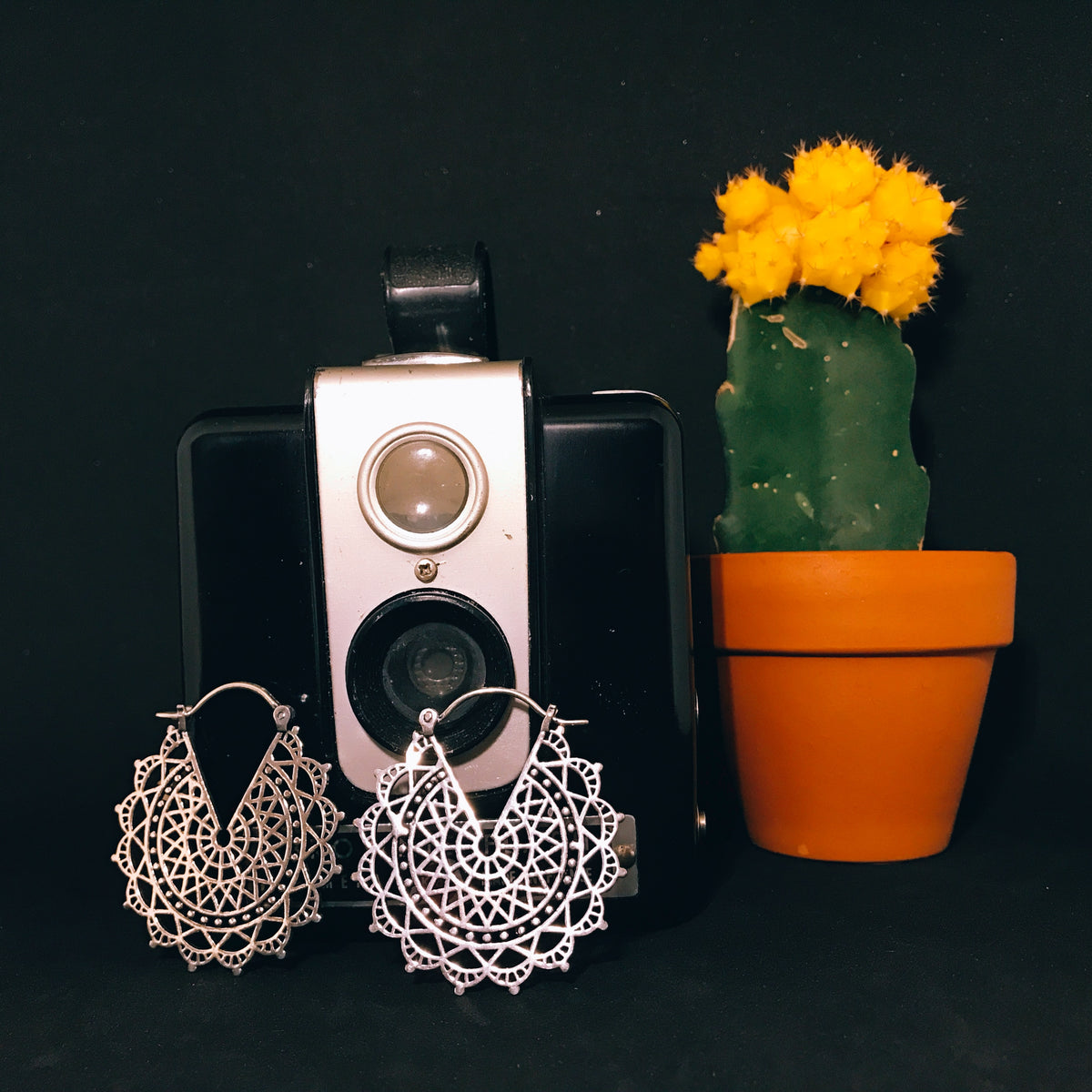 Pair of filigree medallion drop earrings laid flat - Let's Jam, Camden Market, London