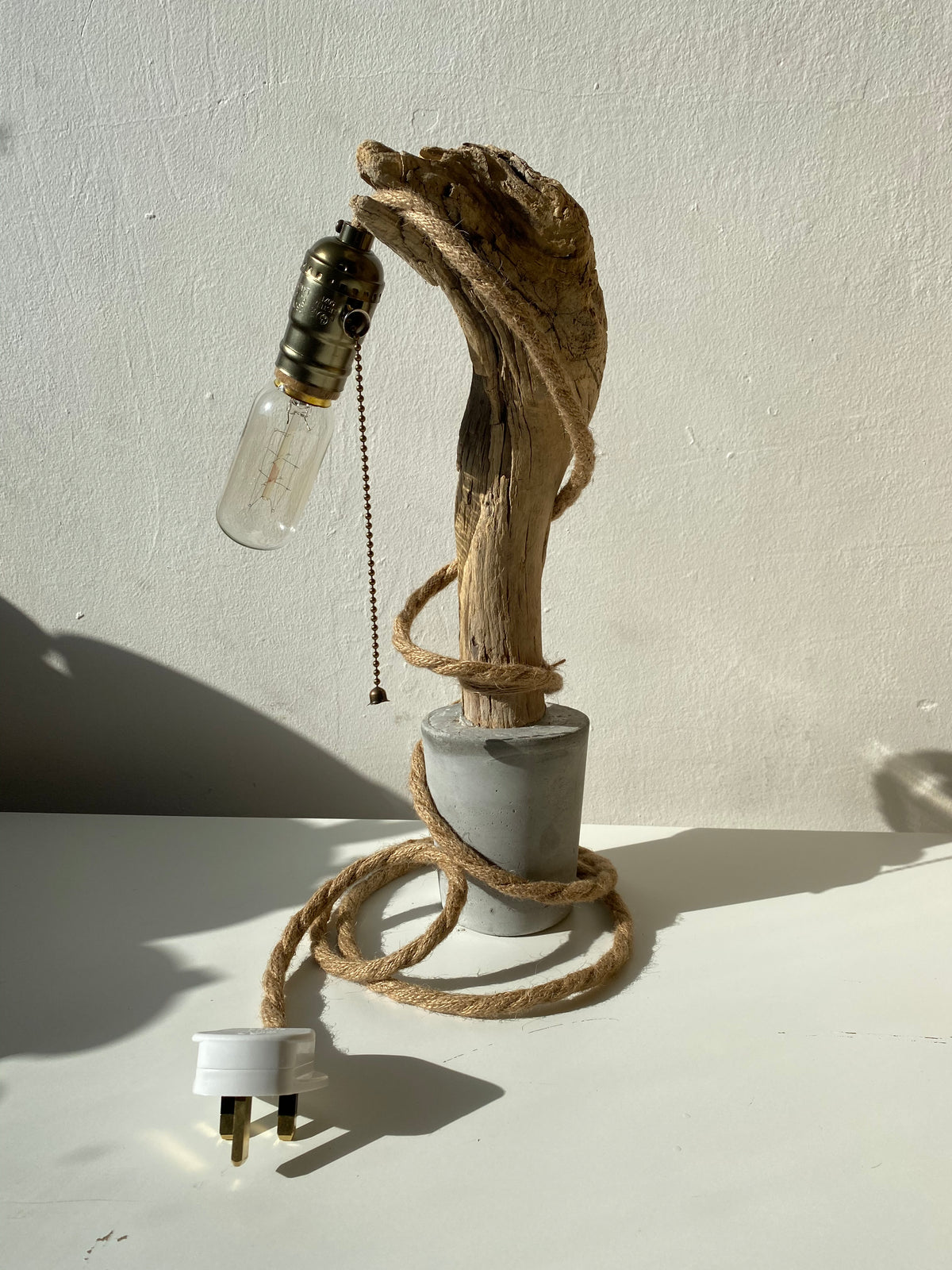Side view of the raw concrete base and its wooden arm - Let's Jam lighting, Camden Market, London