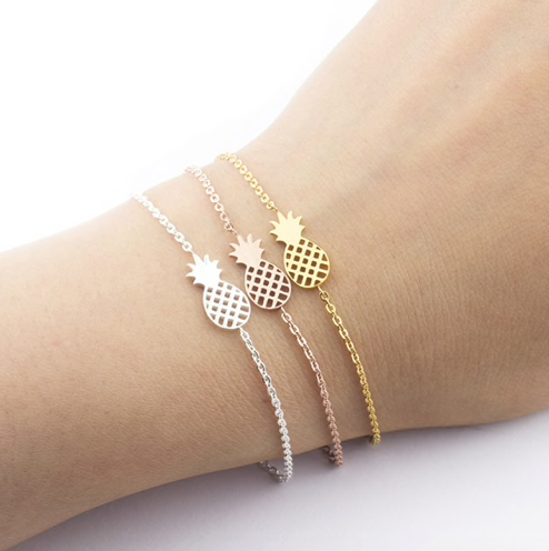 Gold, silver, and rose gold pineapple charm bracelets layered on wrist - Let's Jam jewellery collection