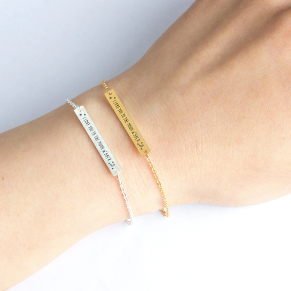 Gold and silver bar bracelets engraved with 'I Love You To The Moon & Back', worn on wrist - Let's Jam jewellery collection