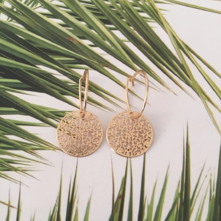 Gold-tone filigree disc hoop earrings laid on a palm leaf backdrop - Let's Jam jewellery collection