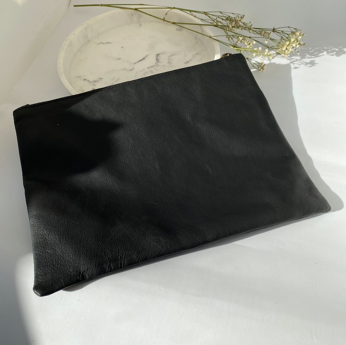 Handmade leather clutch bag shown flat, zip running along the top edge - Let's Jam, Camden Market
