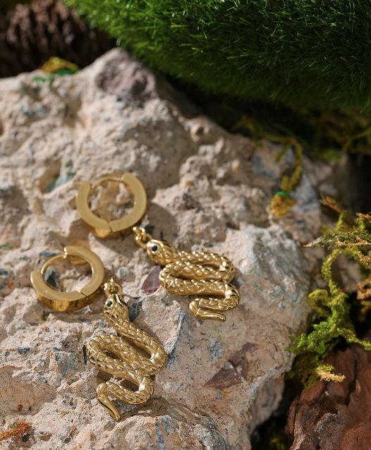 Long gold snake earring dangling below the lobe in a studio portrait - Let's Jam, Camden Market, London