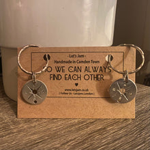 Load image into Gallery viewer, Two matching silver compass keyrings on a Let's Jam "So We Can Always Find Each Other" branded card, propped on a wooden table - Let's Jam collection