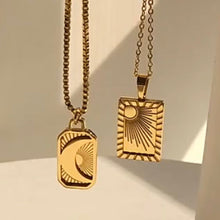 Load image into Gallery viewer, Gold-plated moon and sun pendant necklaces with textured sunburst and crescent moon charms, hung together against a sunlit architectural backdrop - Let's Jam jewellery collection