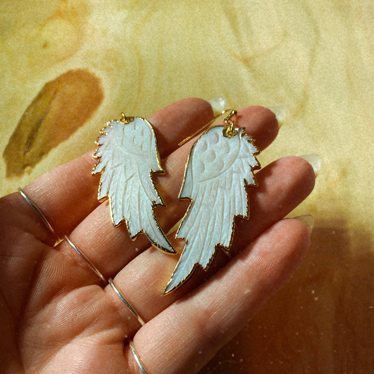 Pair of white mother of pearl angel wing drop earrings with gold-plated trim - Let's Jam, Camden Market London