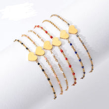 Load image into Gallery viewer, A row of gold-tone chain bracelets with yellow enamel heart charms and colourful beaded accents in red, pink, black and navy - Let's Jam jewellery collection