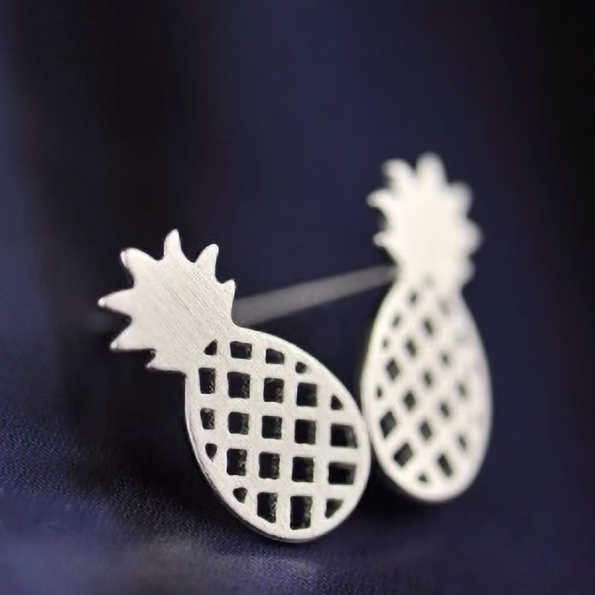 925 sterling silver pineapple stud earrings with cut-out textured detail, laid flat on a dark background - Let's Jam jewellery collection